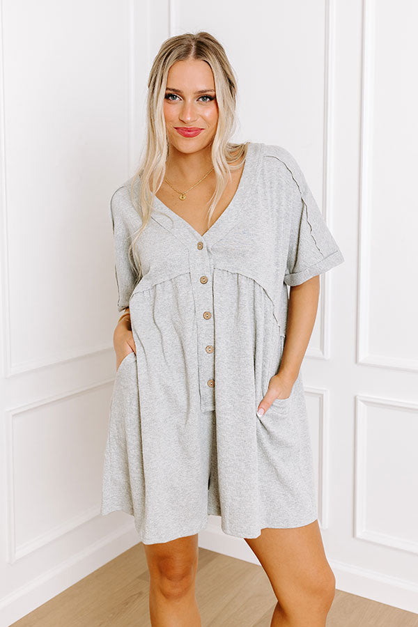 A relaxed grey button-down romper, a stylish choice for vacation clothes or casual chic.