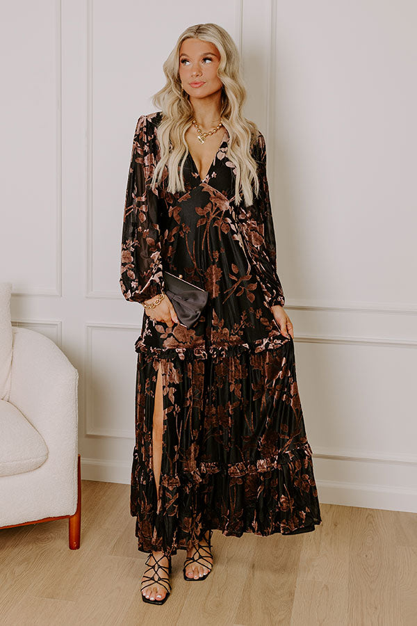 Elegant black velvet burnout maxi dress with floral details, styled for a sophisticated winter evening.