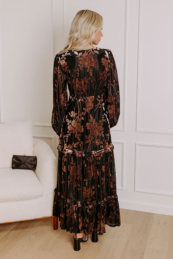 Sophisticated black velvet burnout maxi dress featuring long sleeves and a tiered skirt for a seasonal look.